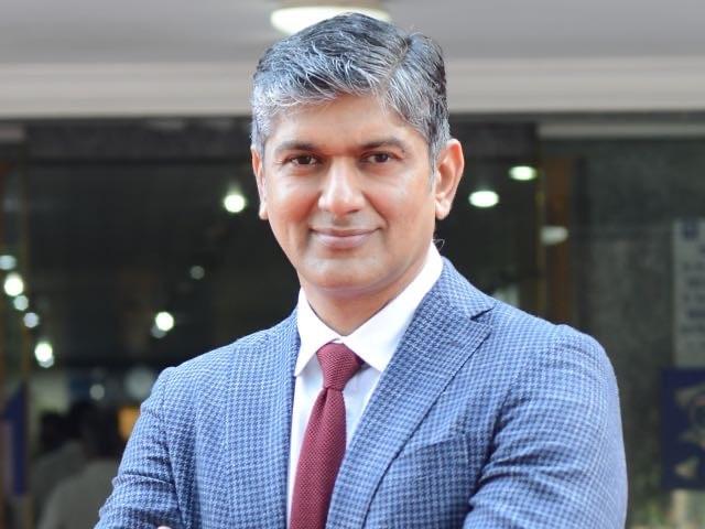 Dr. Sri Ganesh is wearing a red bow tie and blue suit in an indoor setting.