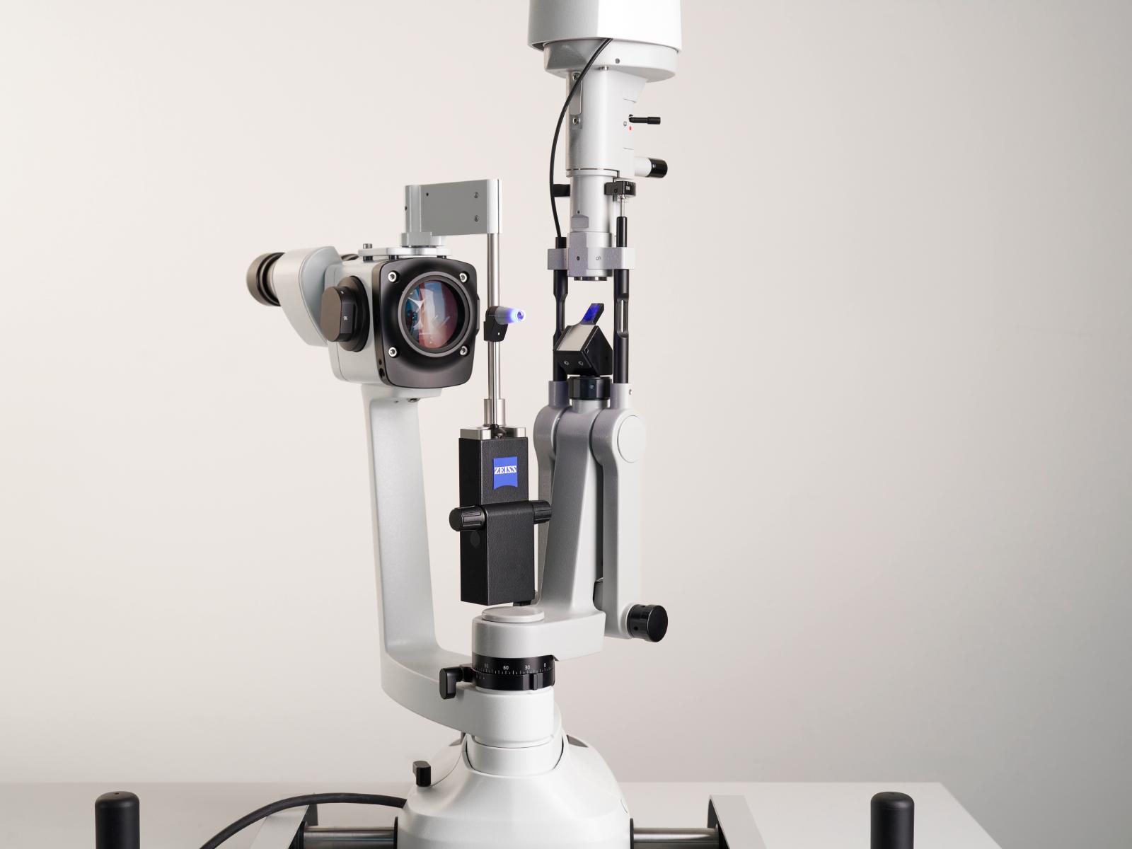 High-precision ophthalmic slit lamp microscope with integrated camera and adjustable components mounted on a table.