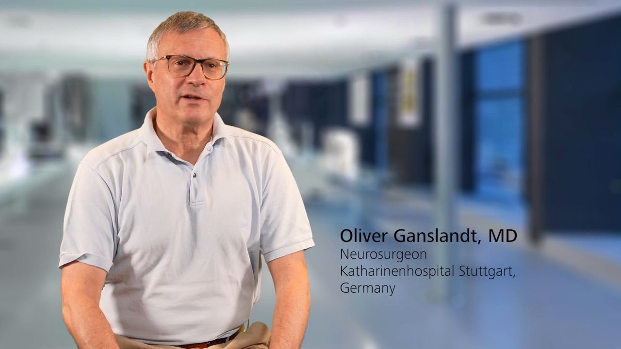 Oliver Ganslandt, MD, Neurosurgeon at Katharinenhospital Stuttgart, Germany, is speaking in a modern medical facility setting, background features a blurred clinical environment with ZEISS branding context.