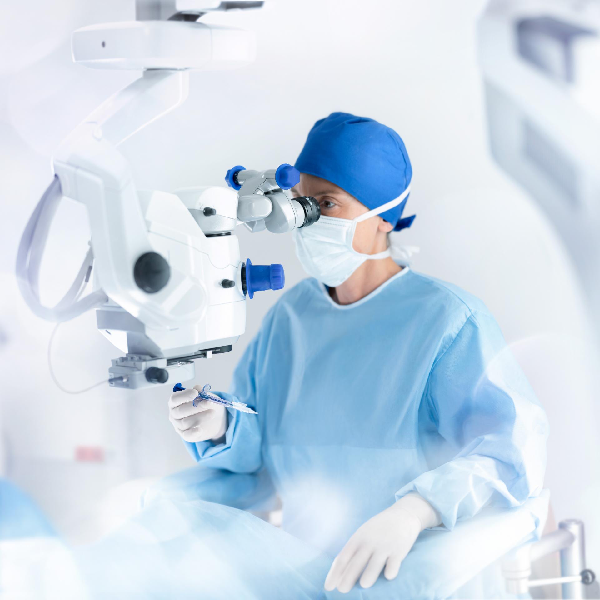 A female surgeon holding the ZEISS AT ELANA injection system during IOL implantation.