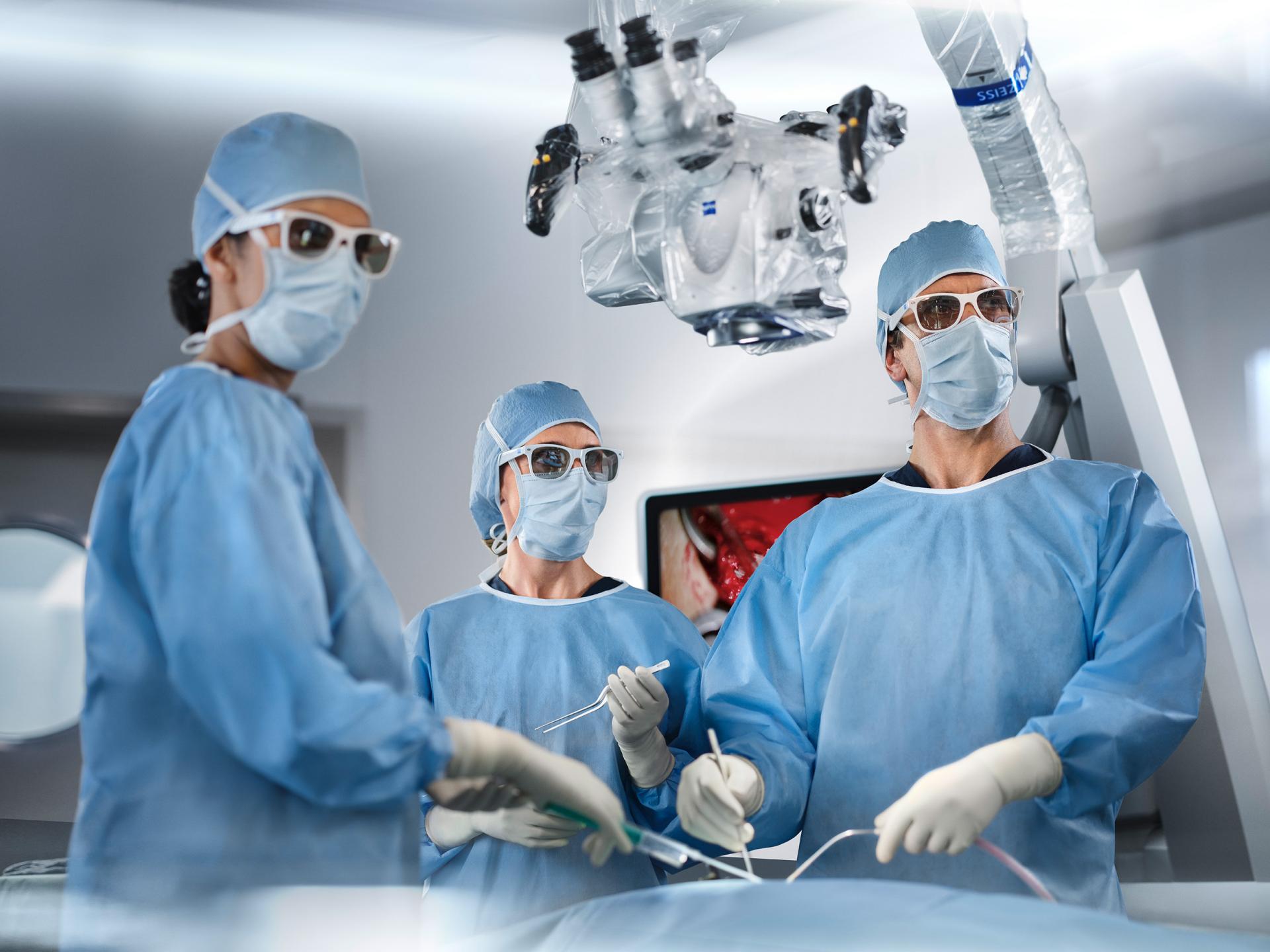 Équipe chirurgicale travaillant avec un exoscope et portant des lunettes 3D de ZEISS.