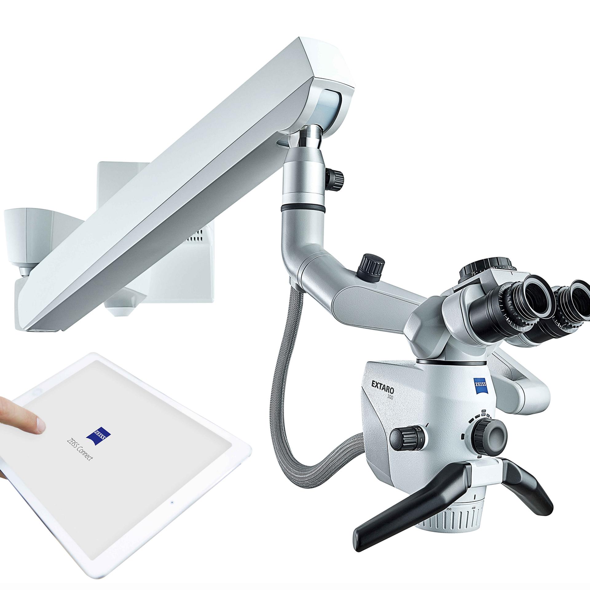 ZEISS surgical microscope system with articulated arm and dual eyepieces, shown alongside a touchscreen tablet displaying the ZEISS logo.