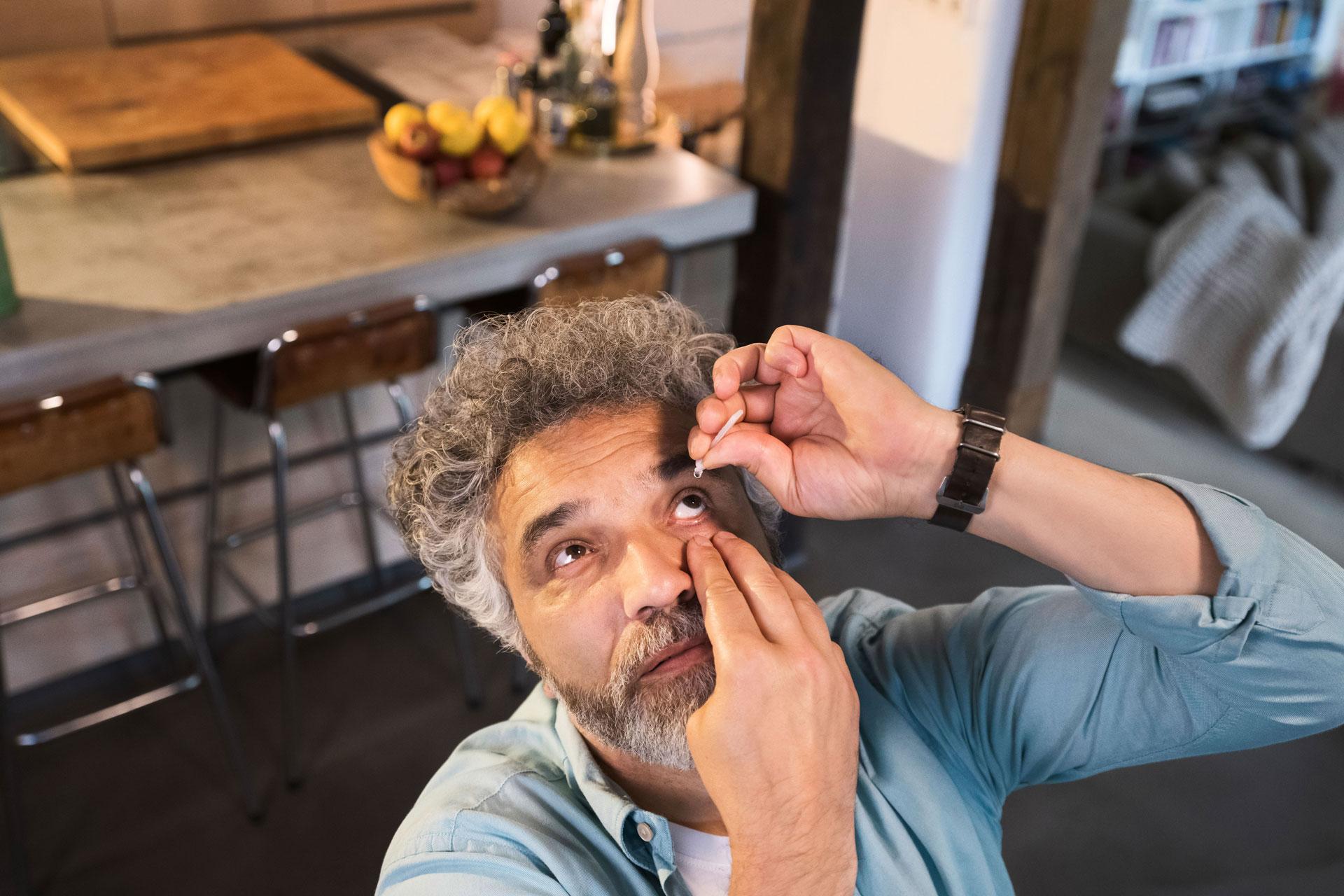 Cataract patient using eye drops after surgery.