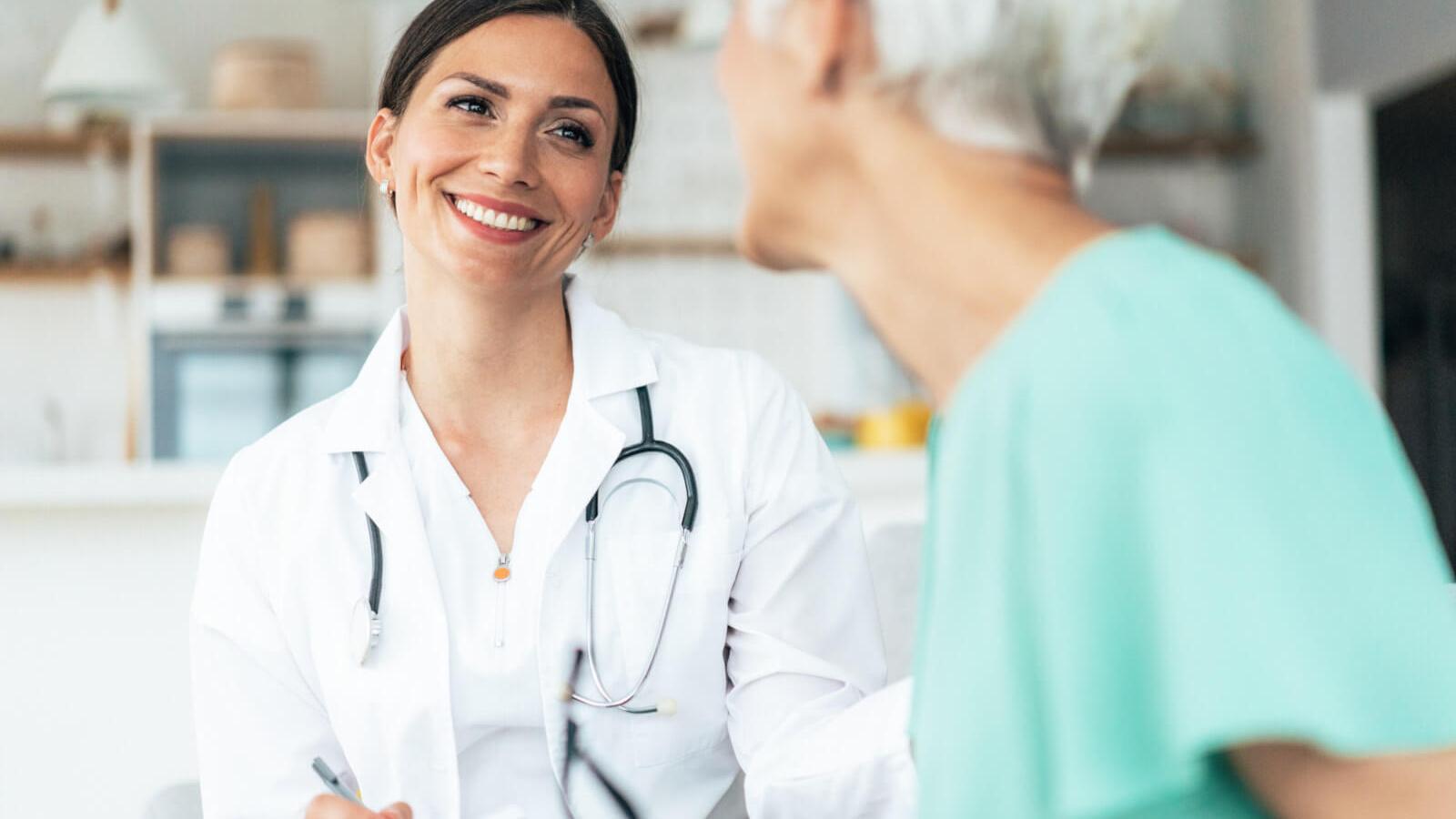 Smiling female doctor talks with patient.
