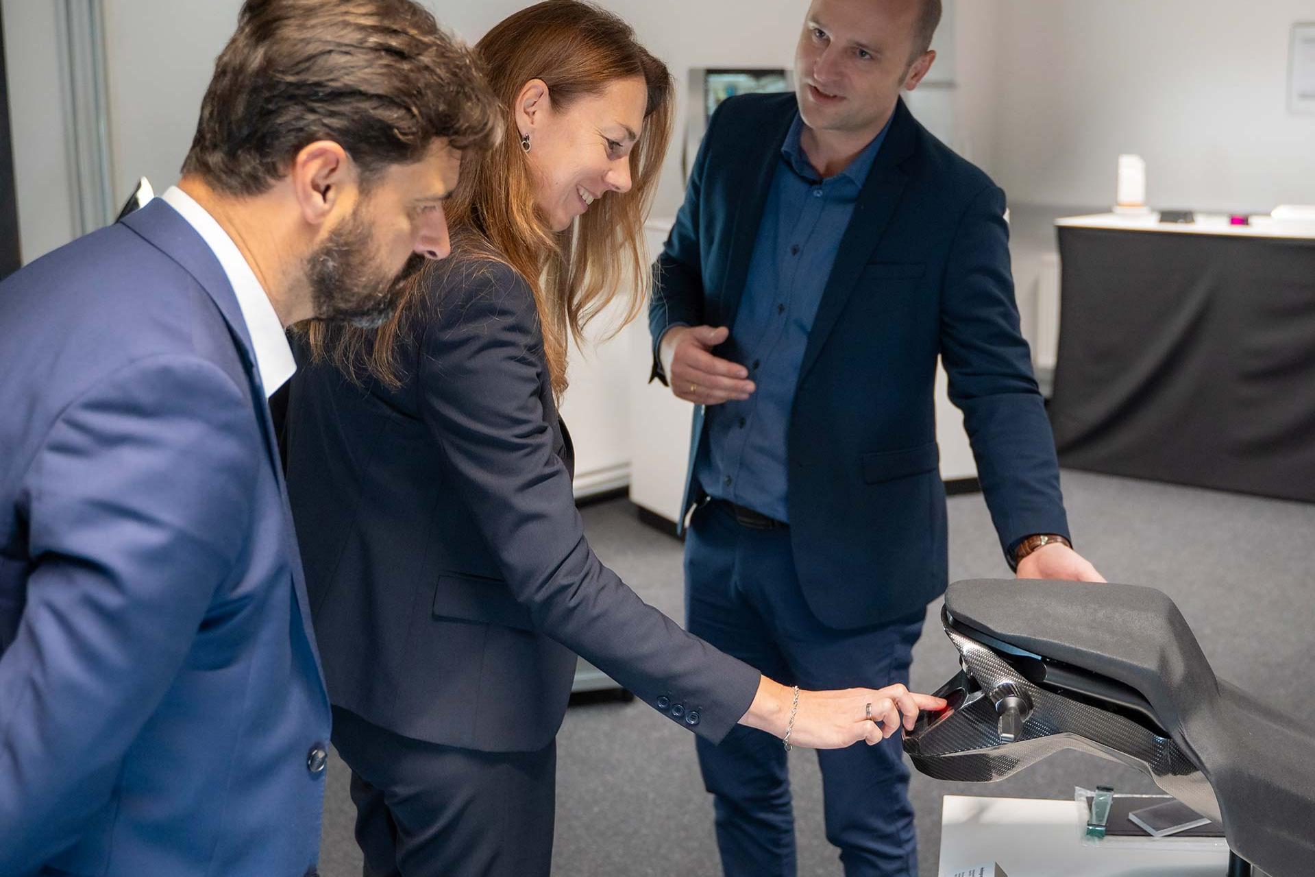 From left: David Caro (Head of BU Automotive, tesa), Dr. Ingrid Sebald (Board Member Technology, tesa) and Dr. Viktor Schütz (Head of Partnership Management, ZEISS Microoptics), showcasing a holographic lighting solution for motorcycles.