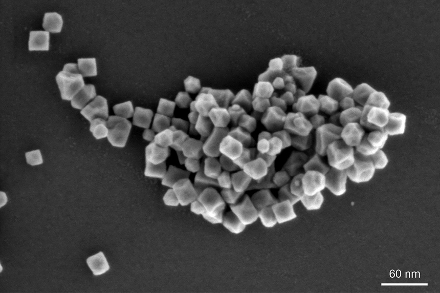 Magnetic, iron manganese nanoparticles where one cuboid particle has an edge length of approximately 25 nm, imaged at low acceleration voltage, ZEISS GeminiSEM 560, Inlens SE image, 1 kV, scale bar 60 nm.