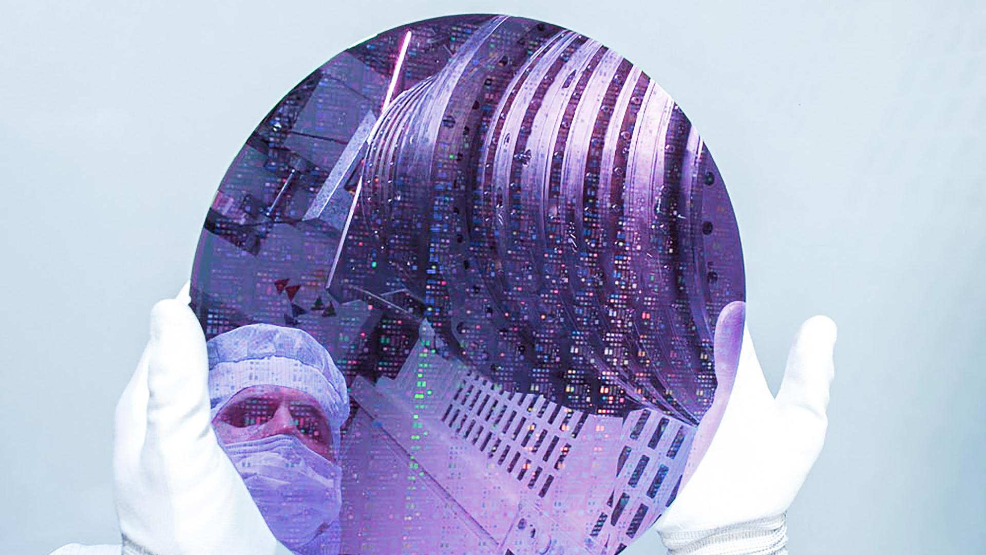 The picture shows a silicon wafer in which a person and a ZEISS Starlith 1700 are reflected.