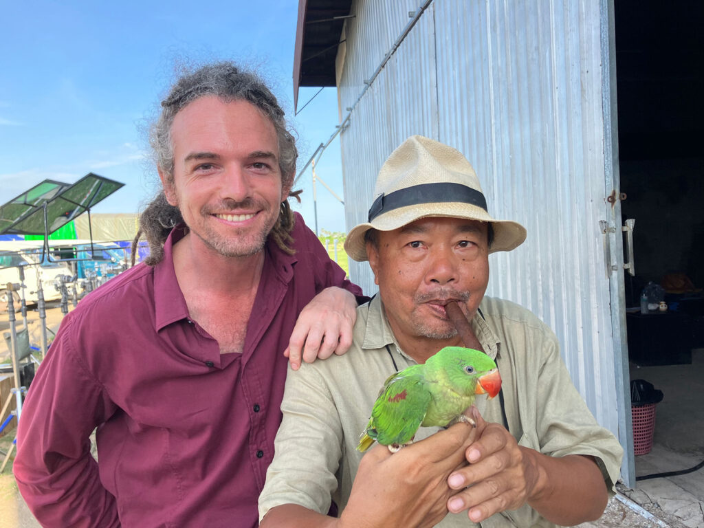 A group of people stands outdoors while a teenage boy reads from a paper as reporters hold microphones toward him.