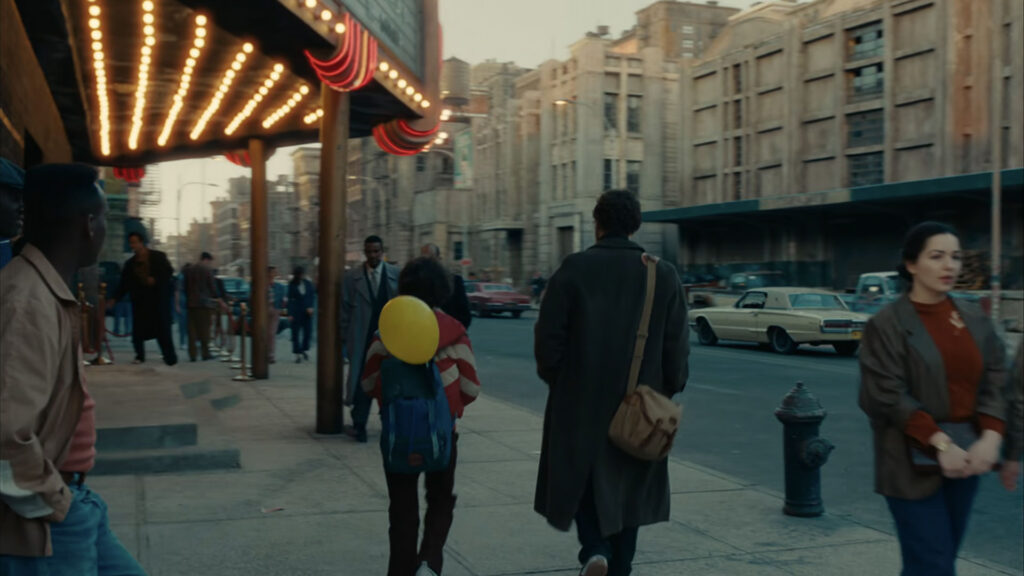 Two people are working with professional film production equipment, including a camera and monitor, in a studio setting featuring ZEISS lenses.