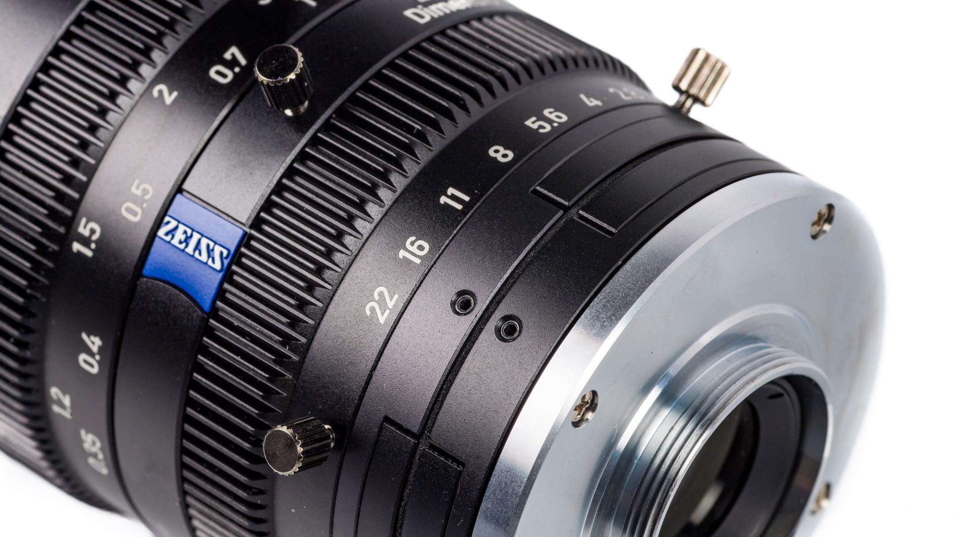 Close-up of a ZEISS professional camera lens showing detailed focus and aperture markings.