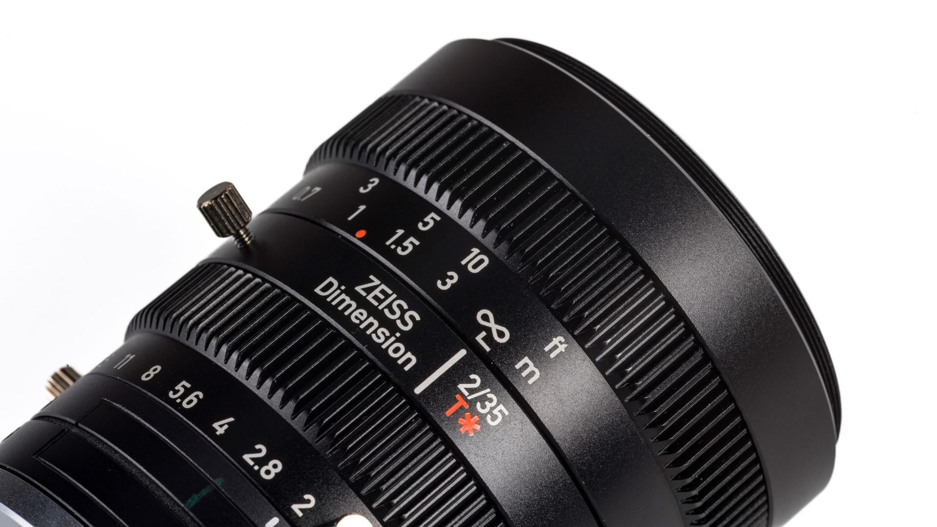 Close-up view of a ZEISS Dimension 21mm T* camera lens showing focus and aperture markings.
