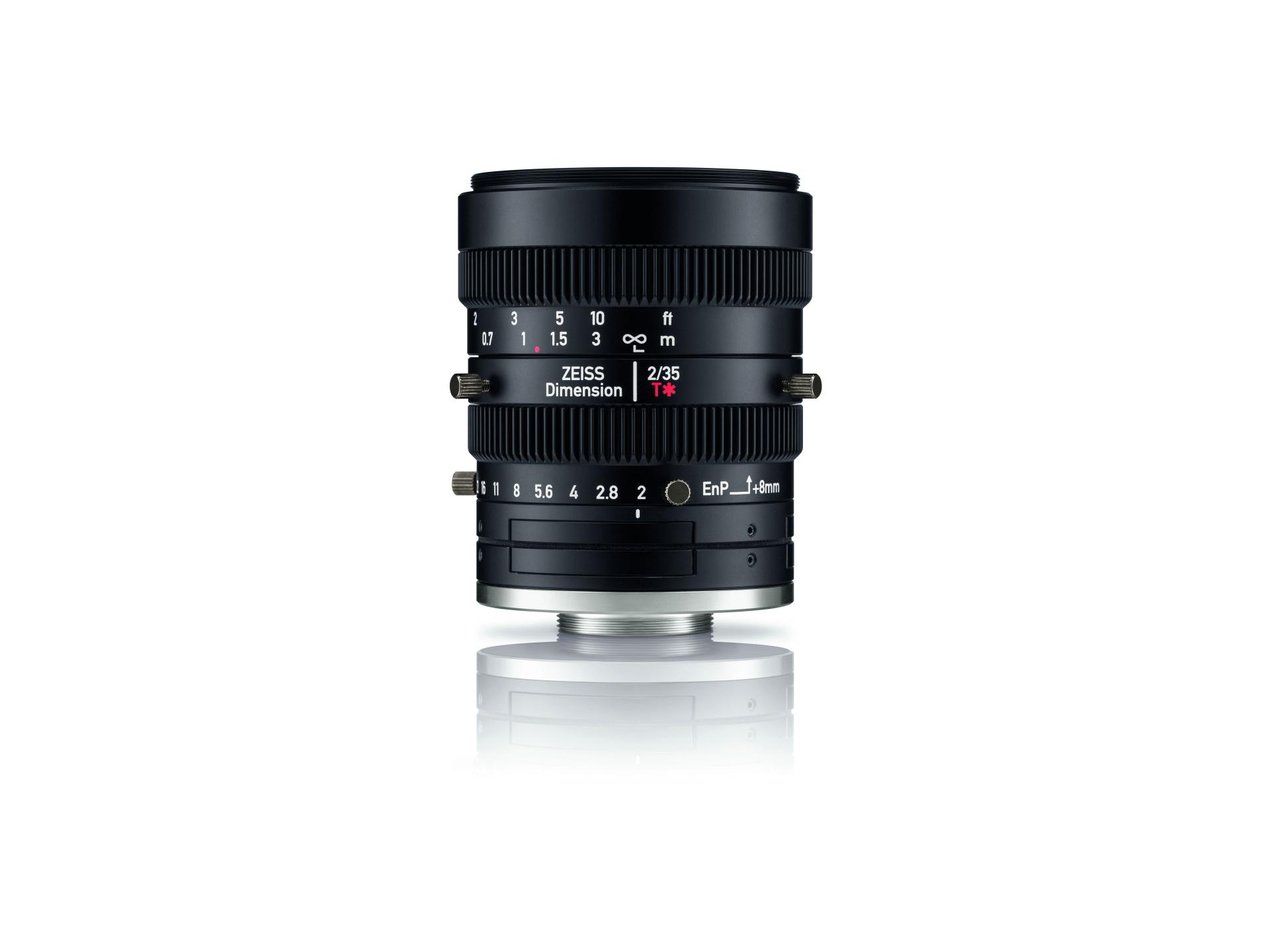 ZEISS Dimension 2/35 industrial lens with focus and aperture markings, shown standing upright on a white reflective surface.