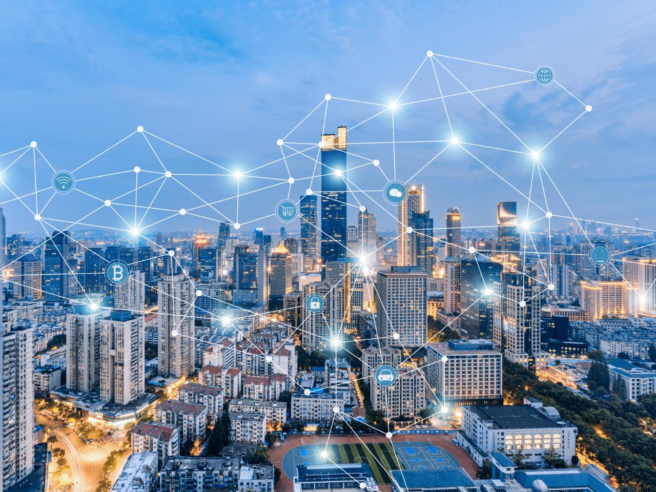 City skyline at night with a digital network overlay, representing digitalization and Urbanization