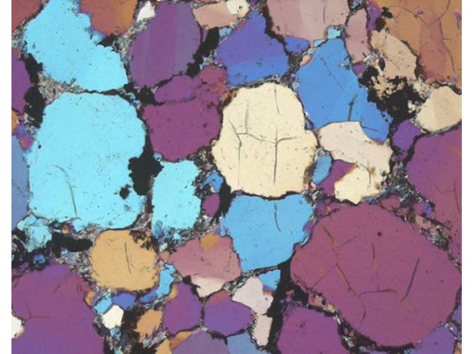 砂岩的复杂多相混合物，通过正交偏光显微镜成像。