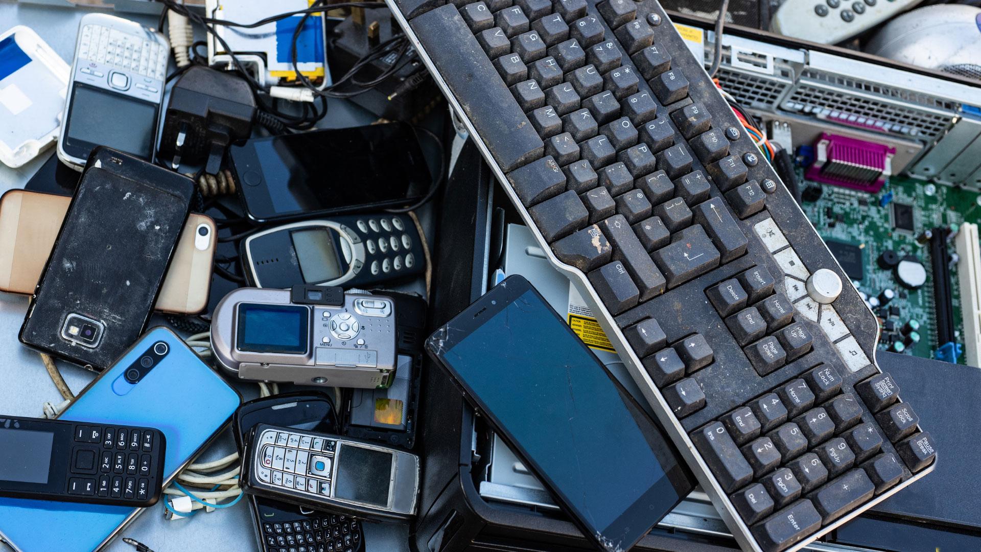 Close up on pile of mixed electronic waste, old broken computer parts and cell phones