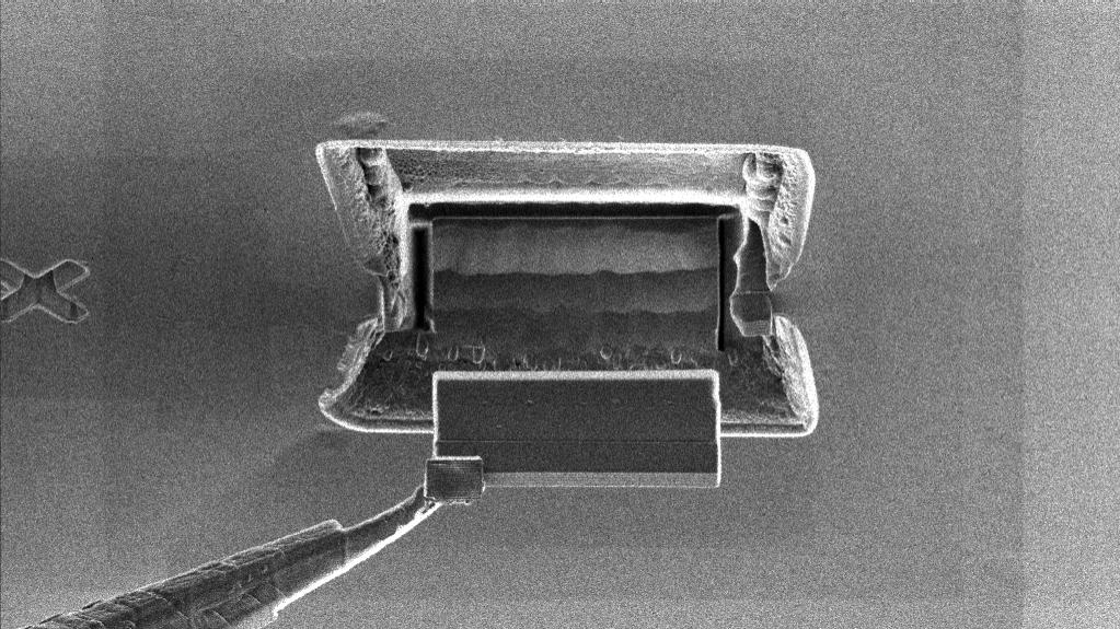 The needle of the micromanipulator with the TEM lamella attached is lifted out from the bulk.