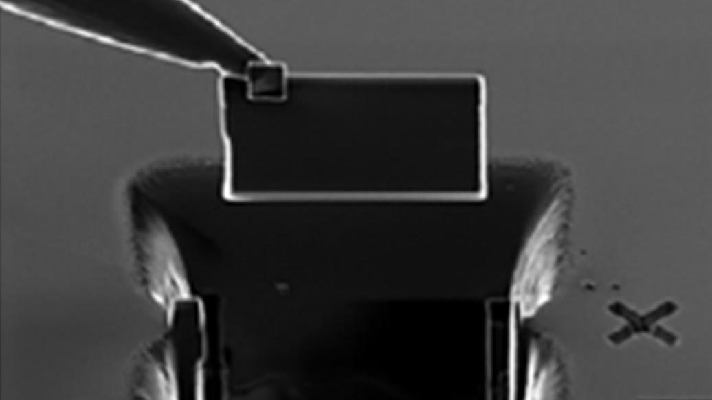 The needle of the micromanipulator with the TEM lamella attached is lifted out from the bulk.