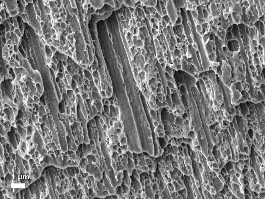 Surface de fracture d'acier inoxydable, image capturée avec des électrons secondaires sous vide poussé.