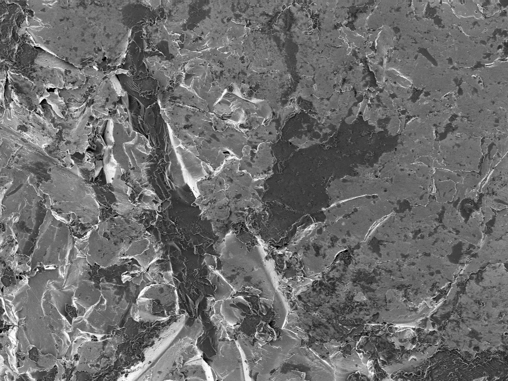 After surface preparation using sand blasting. The crushed SiO2 shows positive charging on the left image. Contrast visible only at large working distance of 5 mm (left) versus a closer working distance of 1 mm (right).