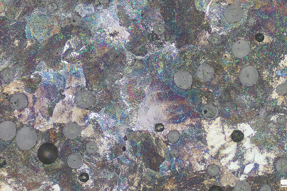 Cast iron with spherulitic graphite. Areas with corrosion and broken out graphite spheres indicate refurbishing of samples.