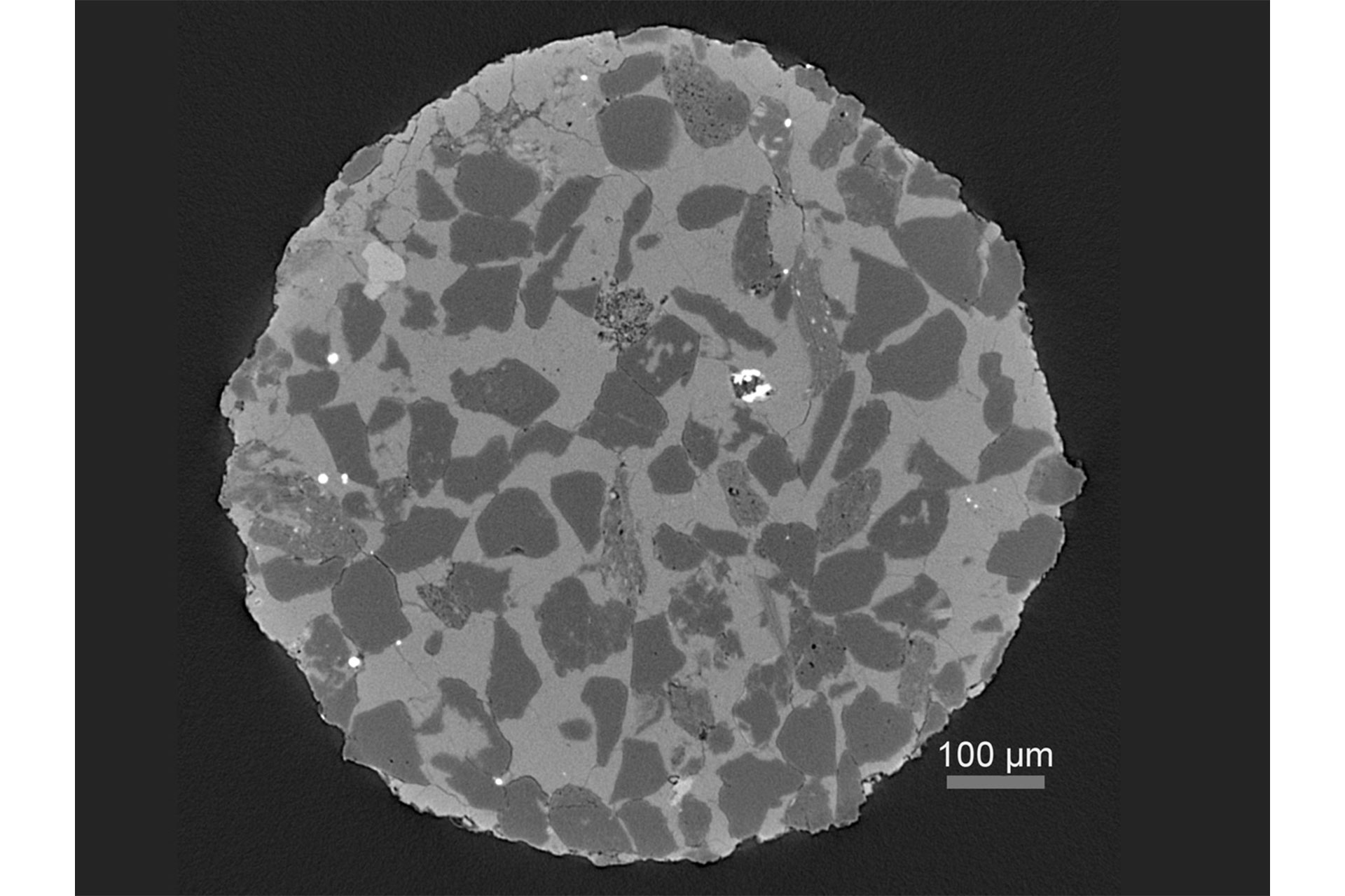 Virtual cross section through a heterogeneous rock sample revealing multiple phases and porosity.