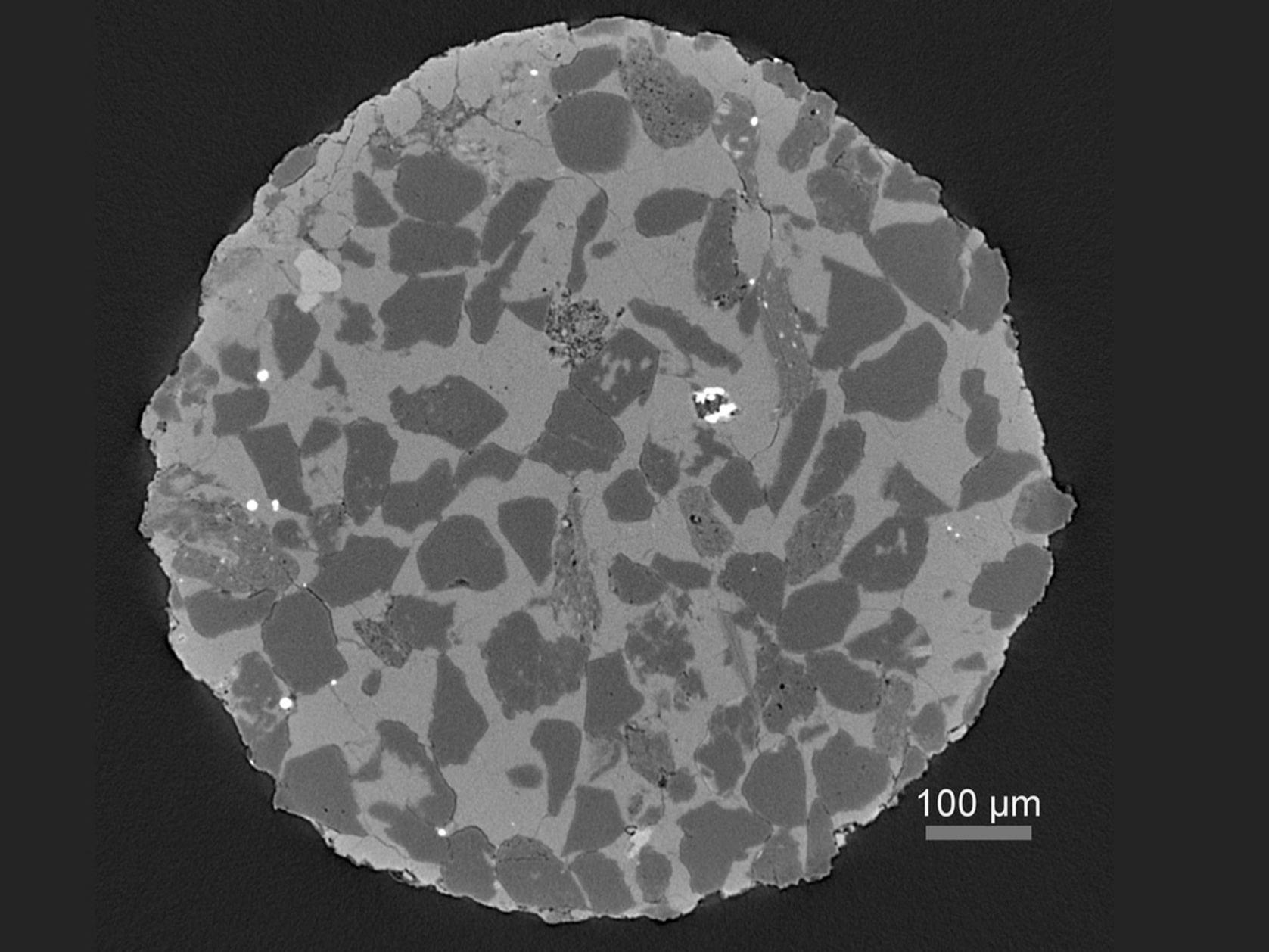 Virtual cross section through a heterogeneous rock sample revealing multiple phases and porosity.