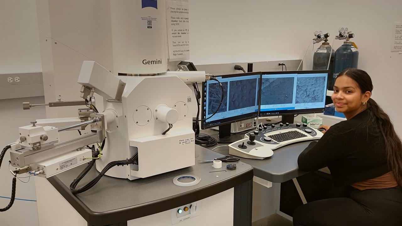 Undergraduate student seated at ZEISS Sigma field emission scanning electron microscope