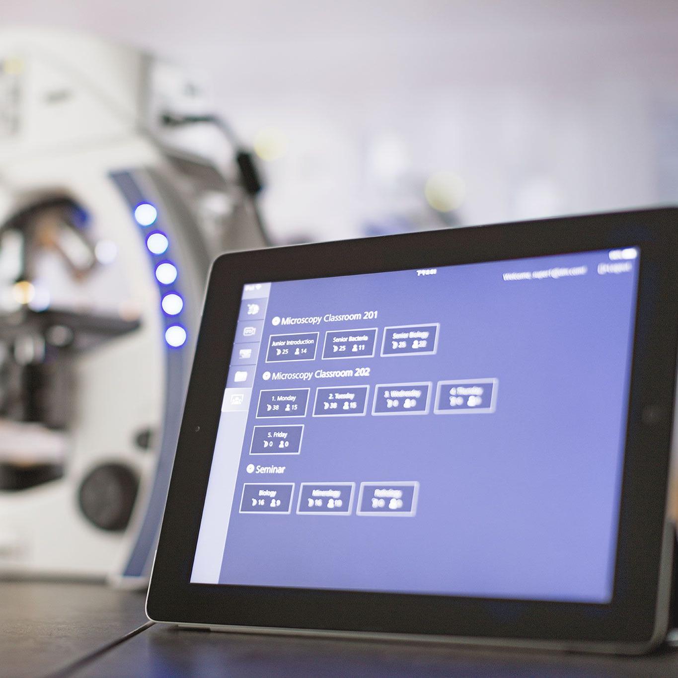 Image of ZEISS Labscope classroom software running on a tablet, sitting on top of a table next to a ZEISS Primostar microscope