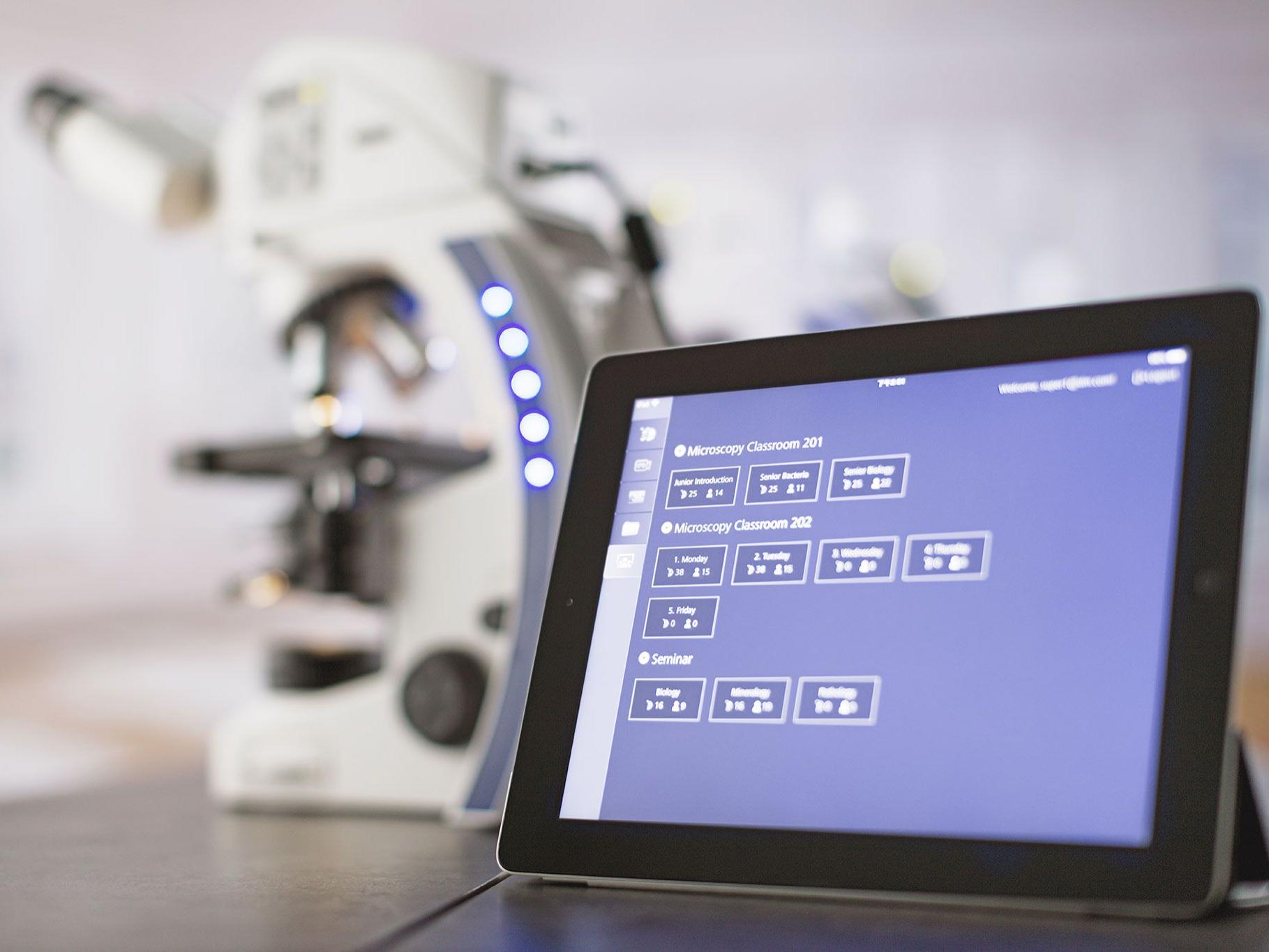 Image of ZEISS Labscope classroom software running on a tablet, sitting on top of a table next to a ZEISS Primostar microscope