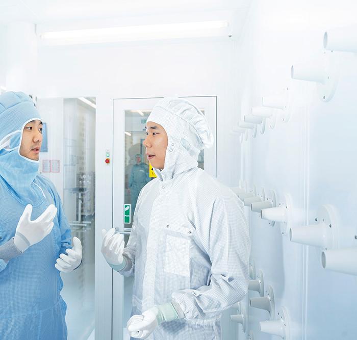 Two employees of SMT Process Control Solutions chat in the ZEISS SMT clean room