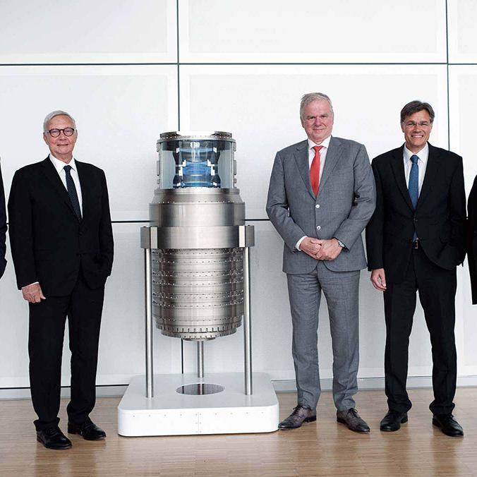 Anniversary celebration with management marking 50 years of ZEISS SMT - photographed in front of lithography optics