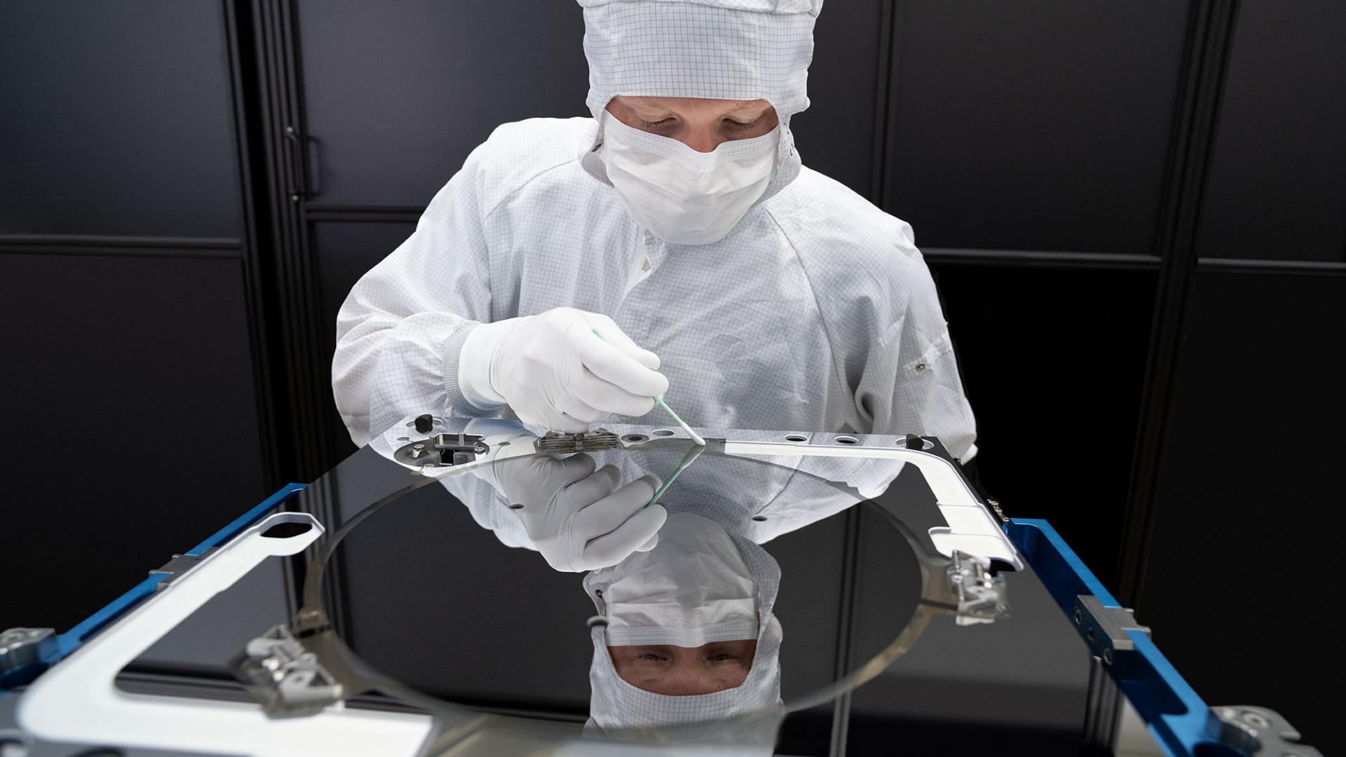 An employee of ZEISS SMT cleans an EUV mirrorblock in a clean room suite