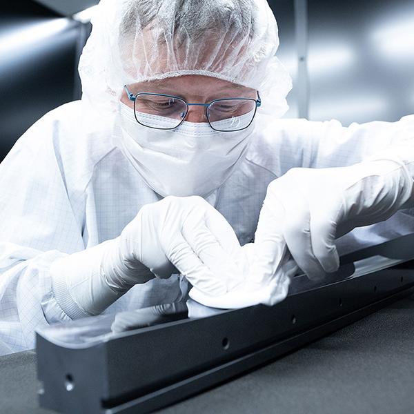 A employee cleans the synchrotron optics x-ray mirror