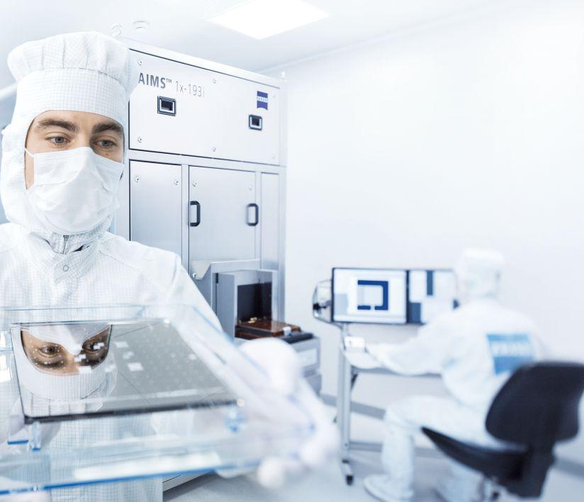 An emoloyee holding a photomask in his hands in the ZEISS SMT clean room 