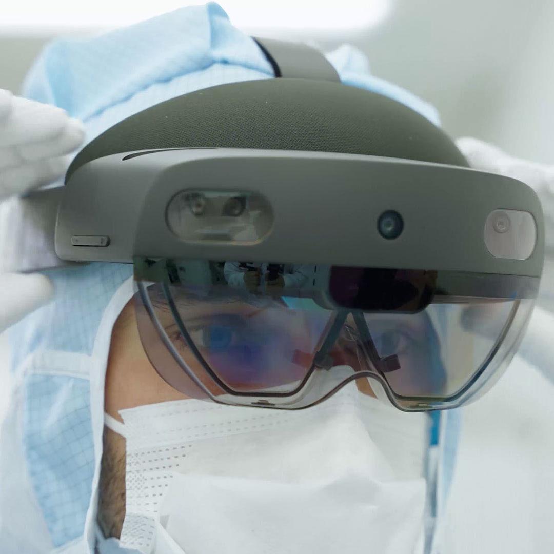 An employee in the clean room at ZEISS SMT with data glasses