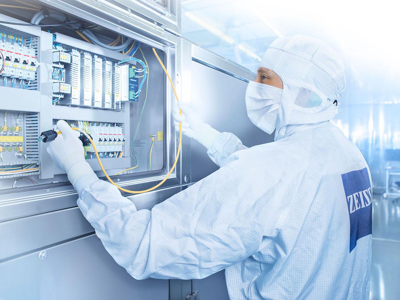 An employee works on an electronic circuit in the clean room at ZEISS SMT