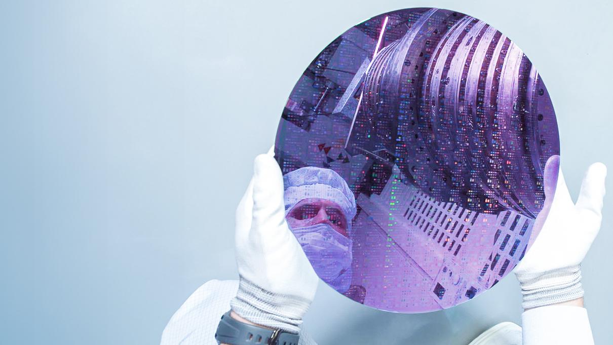 A ZEISS SMT employee holds the important component, which is crucial for the DUV technology, in shape of a thin siliconplate – the so called wafer – in his hands..