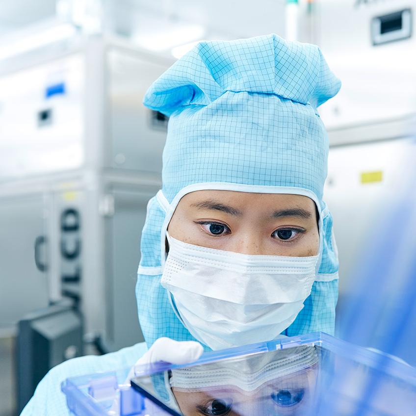 A ZEISS employee works on a Photomask in the clean room.