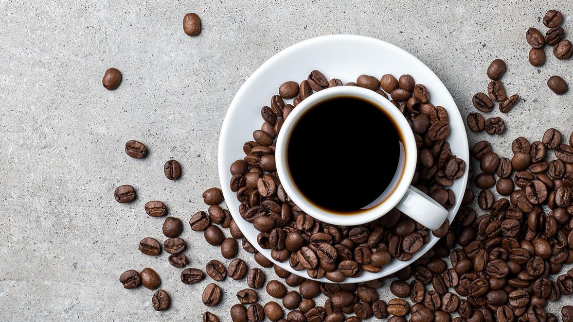 cup of coffee with coffee beans on conrete table