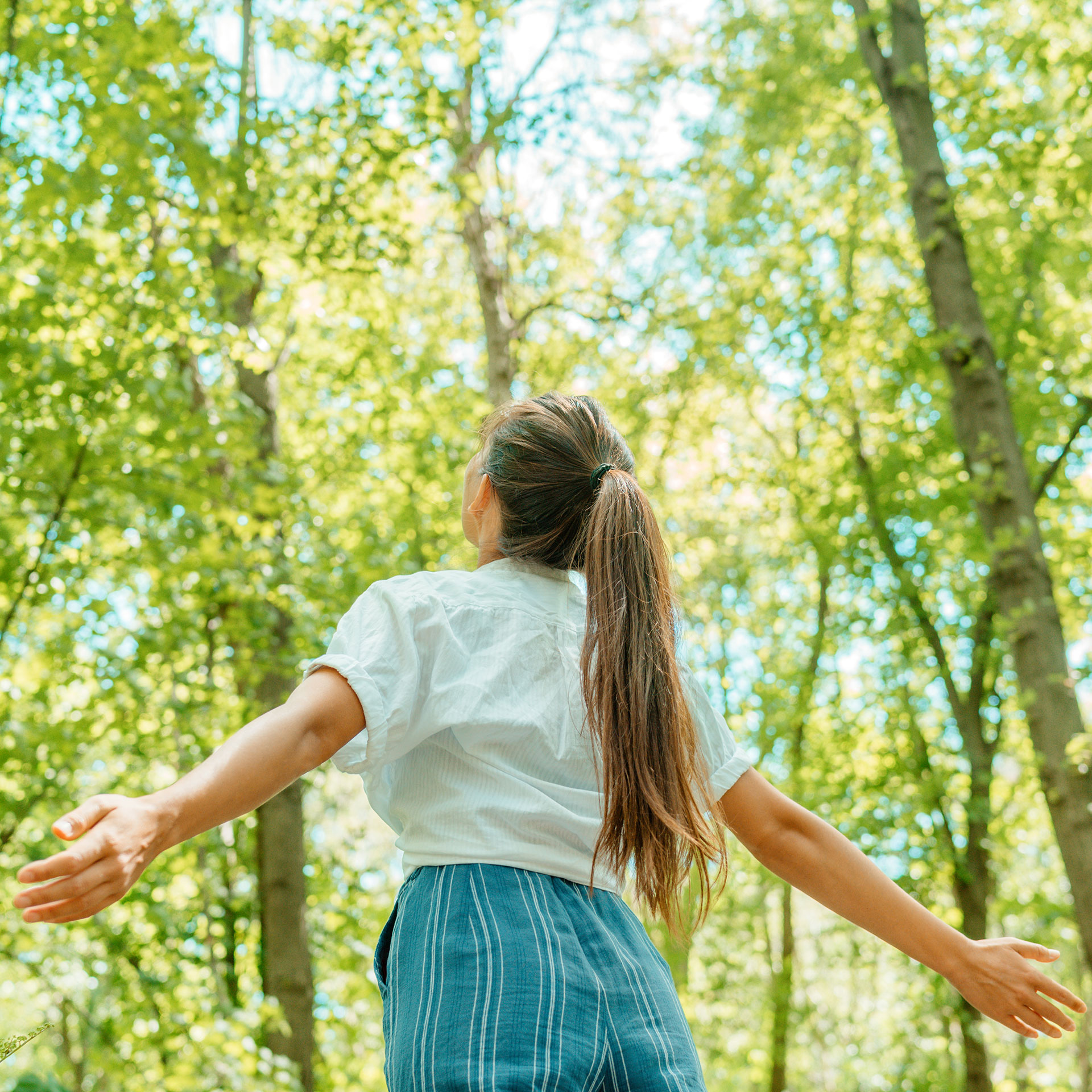 woman breathing clean air in nature forest