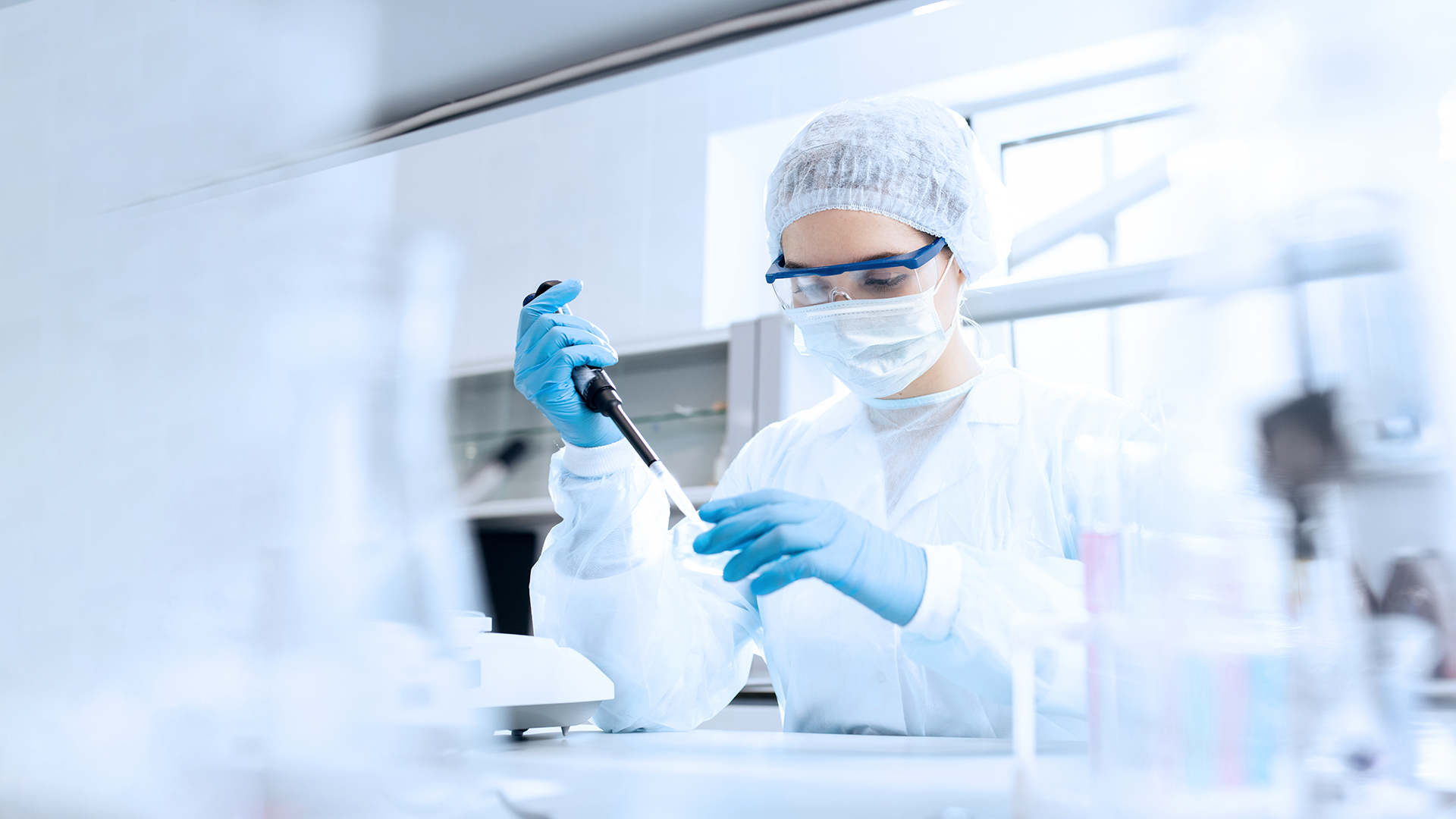 Pharma employee in the laboratory transferring liquid with a pipette