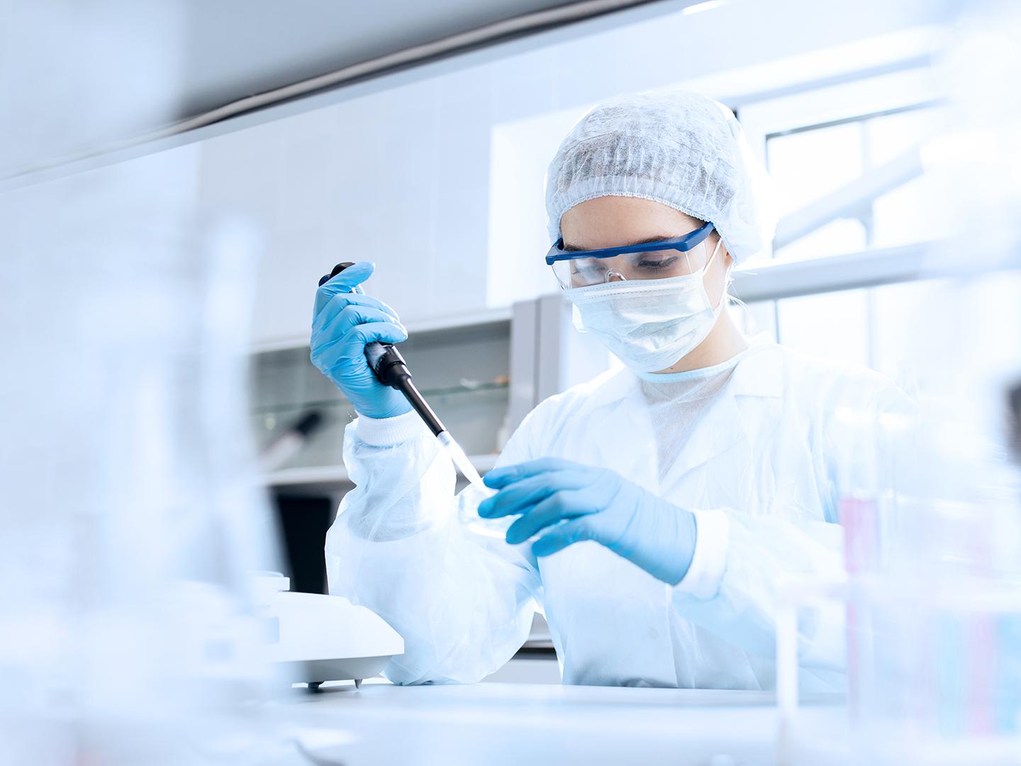 Pharma employee in the laboratory transferring liquid with a pipette