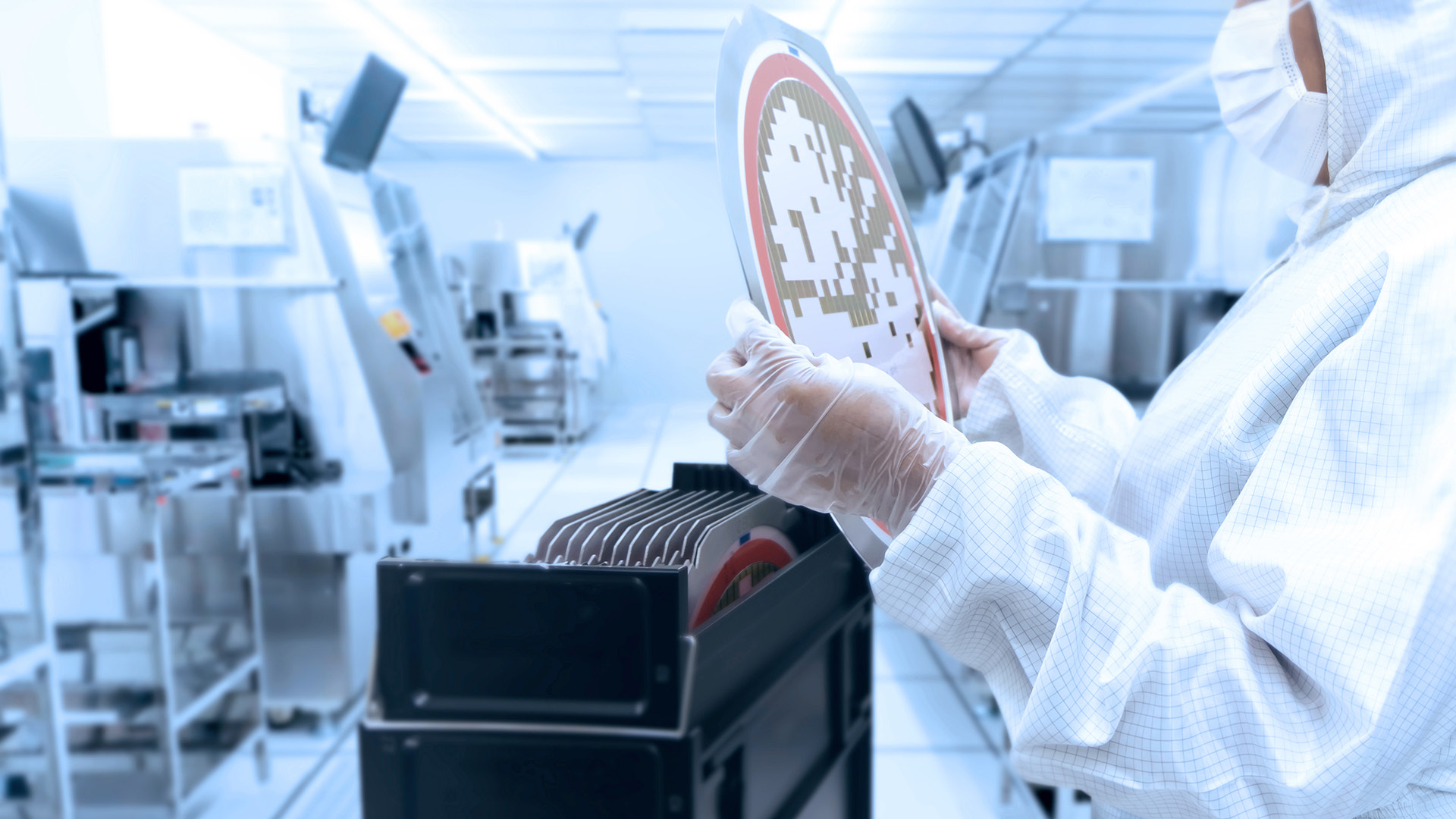 Employee in the clean room holds wafers in his hands