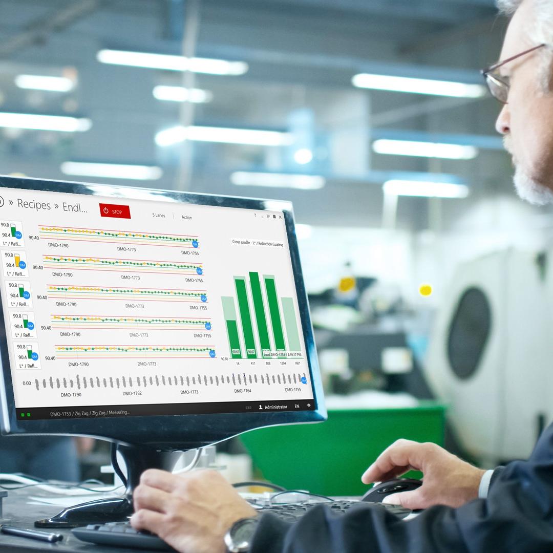 engineer sits in front of the computer in a production environment in his office, the screen show the interface of the thinprocess software 