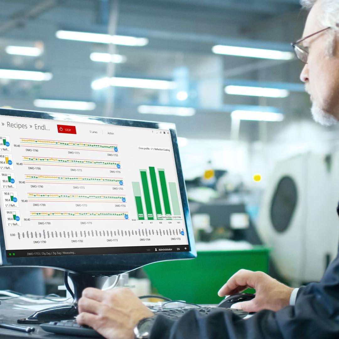 engineer sits in front of the computer in a production environment in his office, the screen show the interface of the thinprocess software 