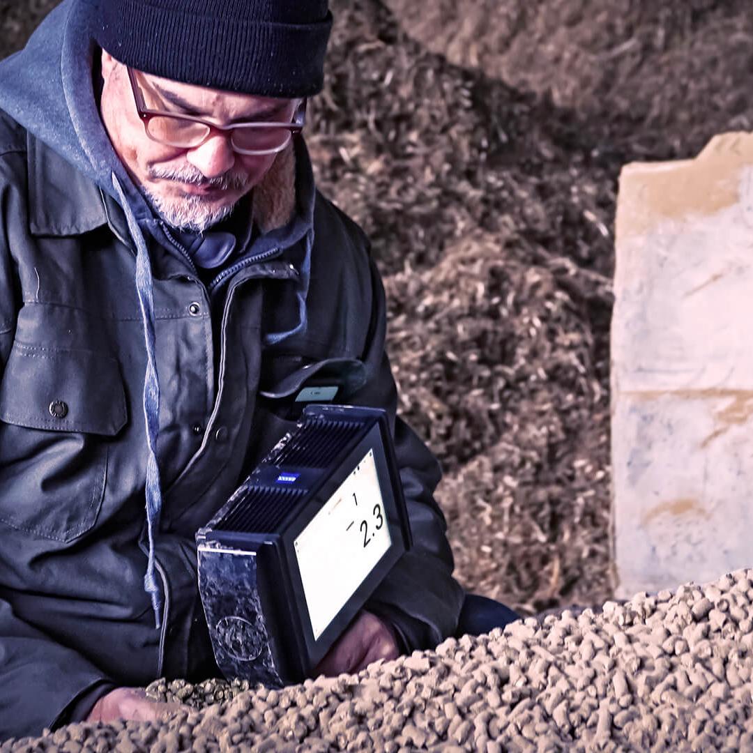Man holds AURA® handheld NIR and measures the sample directly in the field