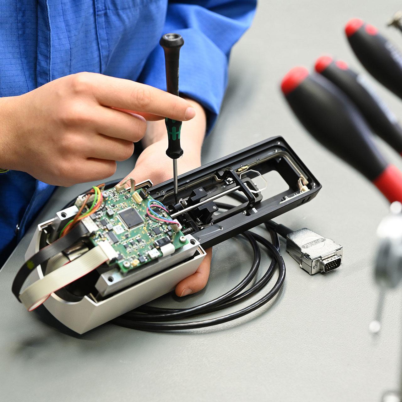 Mechanic adjusts an assembly with printed circuit board