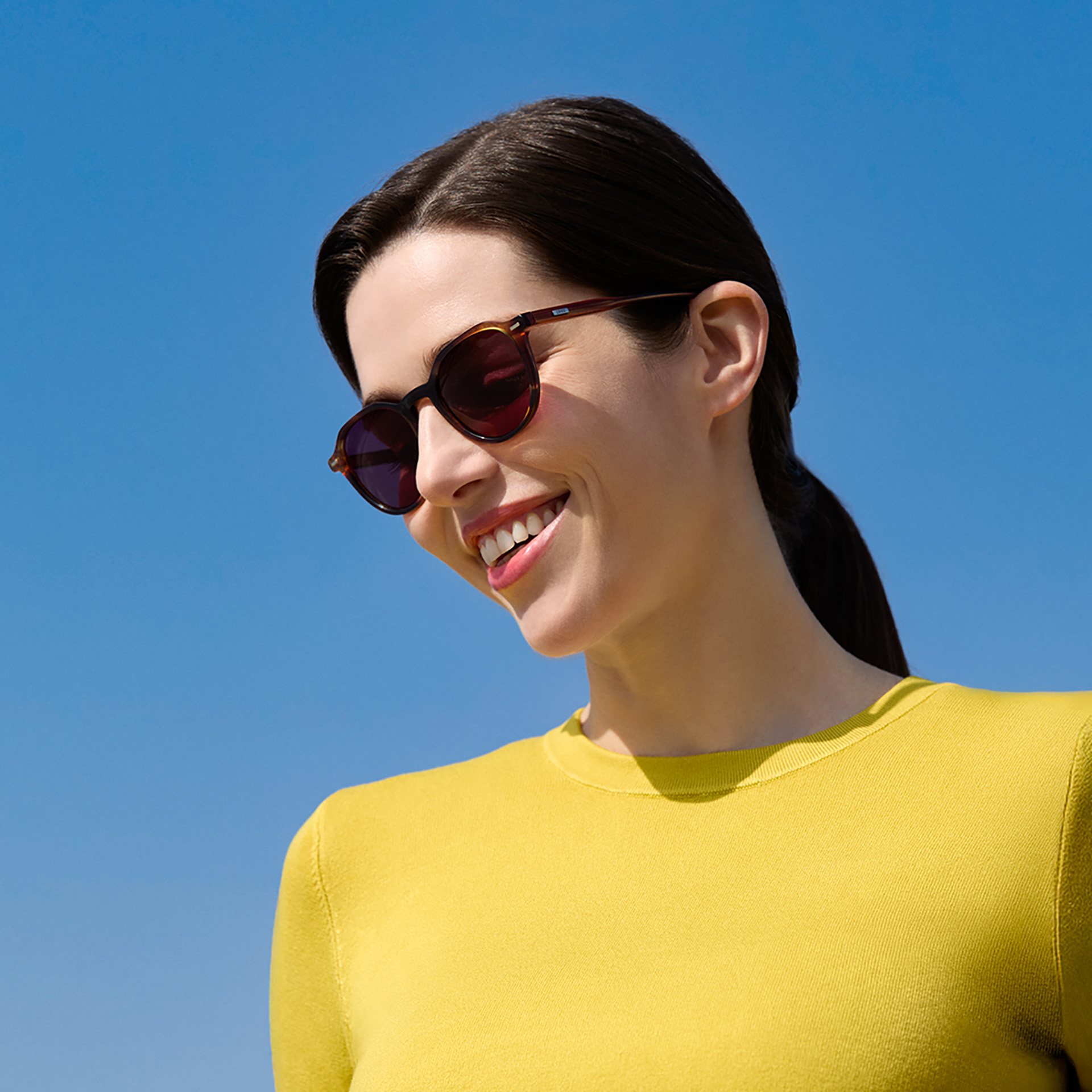 A women wearing ZEISS prescription sunglass lenses in Burgundy.