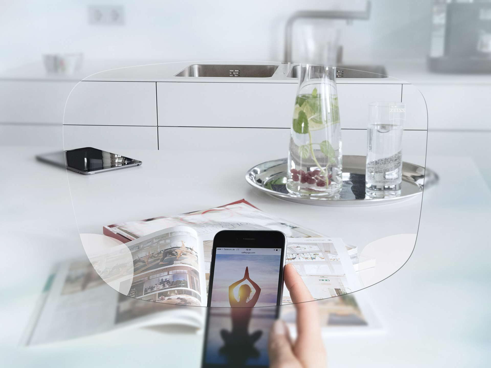 Вид через монофокальные очковые линзы ZEISS EnergizeMe на смартфон и сервированный кухонный стол