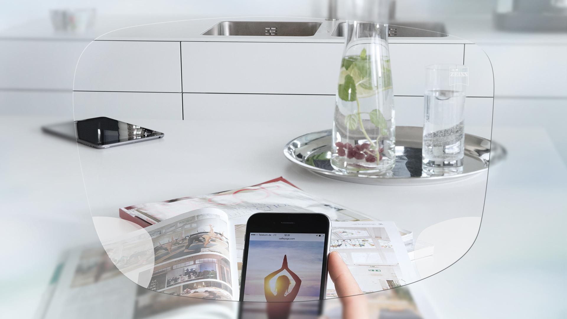 Вид через монофокальные очковые линзы ZEISS EnergizeMe на экран смартфона и сервированный кухонный стол